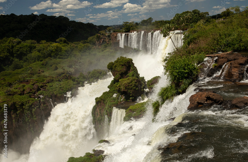 The falls in the tropical rainforest. The rapids flowing across the green jungle and hills into the river. The falls in the tropical rainforest. The rapids flowing across the green jungle and hills into the river.