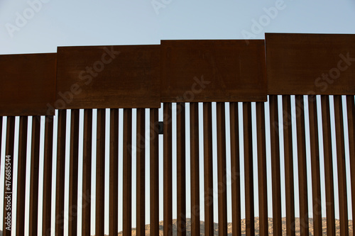 Tecate, Baja California, Mexico - September 14, 2021: Late afternoon sun shines on the USA Mexico border wall as it winds through Tecate.