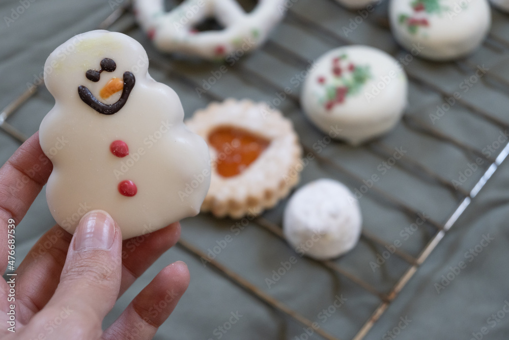 Close-up of hand holding snowman cookie with copy space. Close-up of hand holding snowman cookie with copy space.