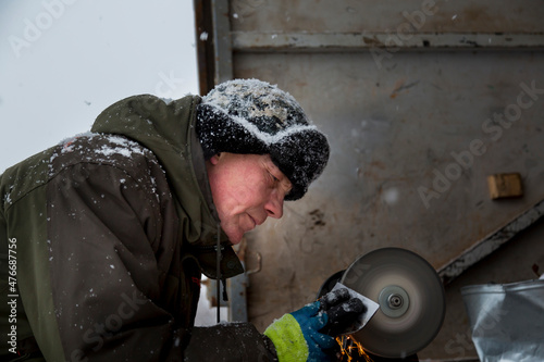 Принти на полотні Worker sharpens a chisel on the emery wheel