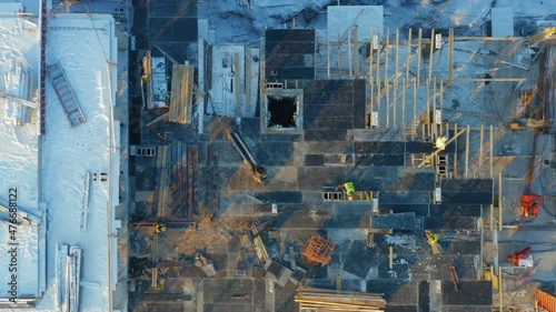 Aerial top-down view of builders lay formwork for pouring concrete for a new floor of a building under construction photo