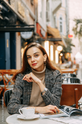 Photography Portrait of a young girl in a brown coat on the background of the Galata Tower