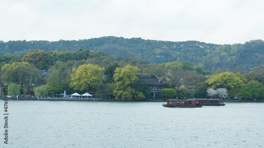 The beautiful lake landscapes in the Hangzhou city of the China in spring with the peaceful lake and fresh green mountains The beautiful lake landscapes in the Hangzhou city of the China in spring with the peaceful lake and fresh green mountains
