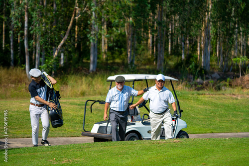 Group of Asian people businessman and senior CEO enjoy outdoor sport golfing together at country club. Healthy men golfer holding golf bag walking on fairway with talking together on summer vacation © CandyRetriever 