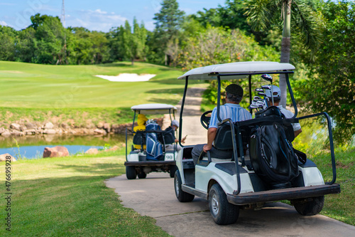 Group of Asian people businessman and senior CEO enjoy outdoor activity lifestyle sport golfing together at golf country club. Healthy men golfer driving golf cart on golf course in summer sunny day