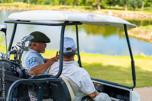 Group of Asian people businessman and senior CEO enjoy outdoor activity lifestyle sport golfing together at golf country club. Healthy men golfer driving golf cart on golf course in summer sunny day