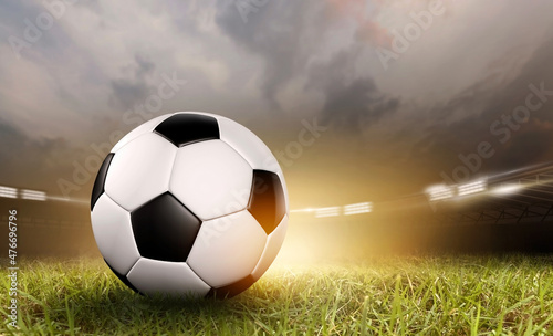 Soccer ball under the spot ray light effects on green field in 3D illustrations, of free space for texts and branding. © DESIGN STOCK