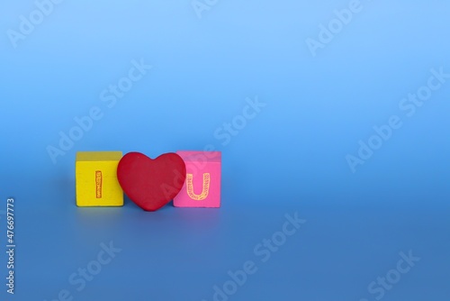 Love and romantic concept. I LOVE U text made from wooden cubes and red heart. © izzuan
