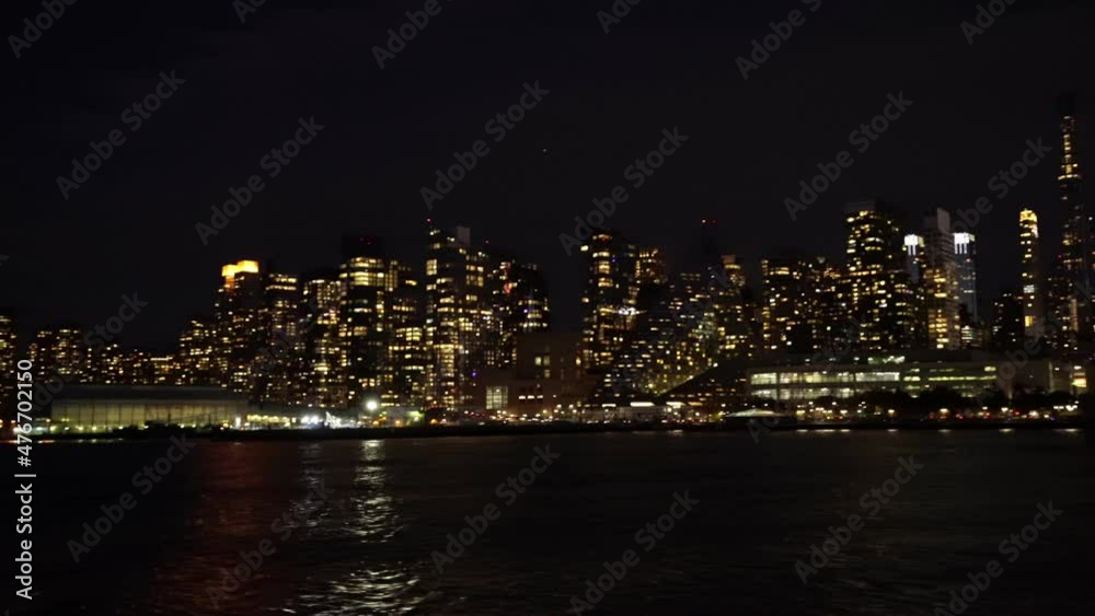 Panoramic view from a ferry boat of New York City skyline illuminated at night Panoramic view from a ferry boat of New York City skyline illuminated at night
