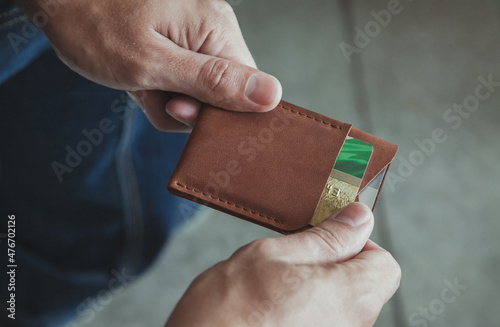 a man takes out a credit card from a cardholder in close-up. Close-up, no face, copy space, horizontal orientation. photo