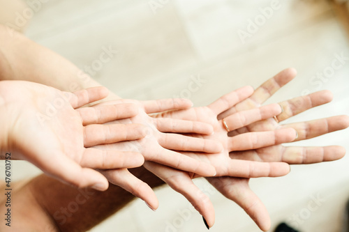 Four hands placed on top of each other palms up  unity of parents and children.