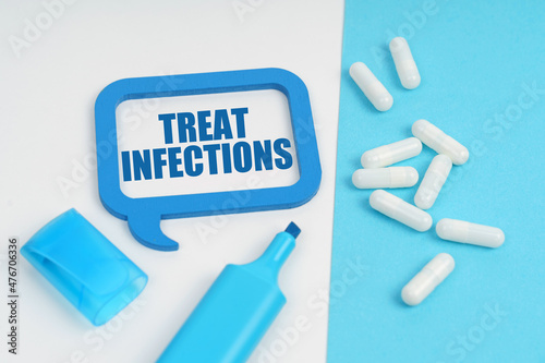 On the white and blue surface are a marker, tablets and a plate inside which the inscription - Treat Infections