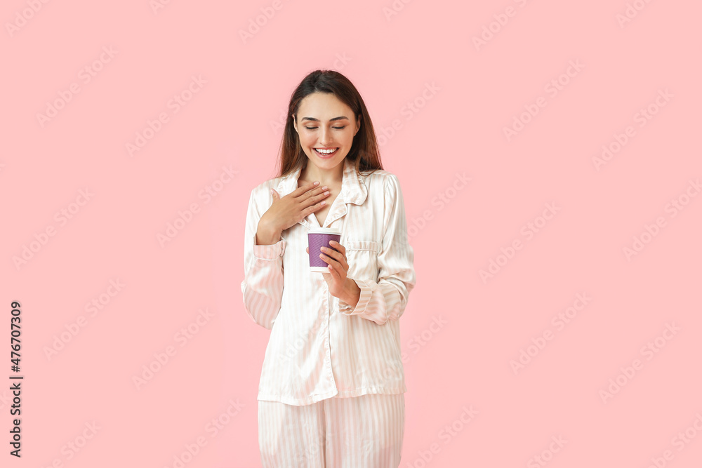 Beautiful woman in pajamas and with cup of coffee on color background Beautiful woman in pajamas and with cup of coffee on color background