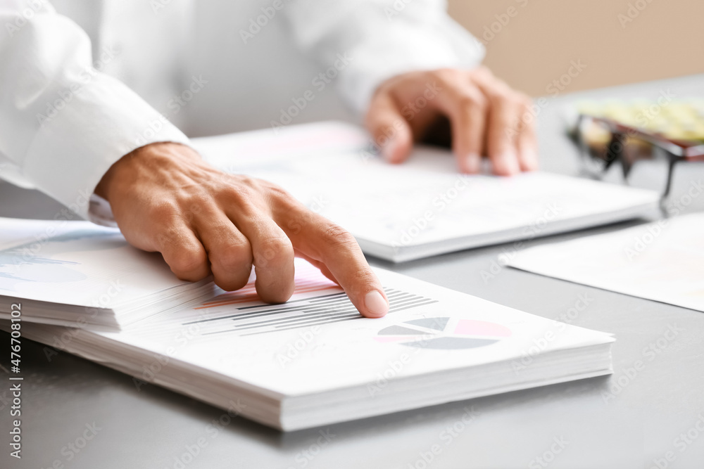 Businessman working with documents at desk in office, closeup Businessman working with documents at desk in office, closeup
