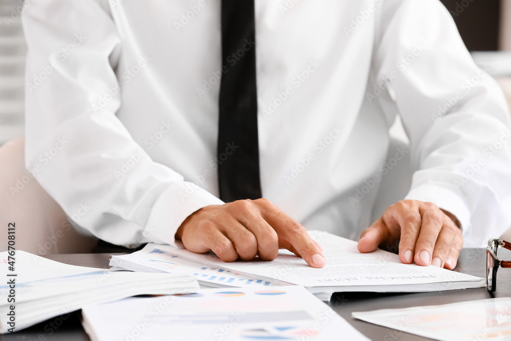 Businessman working with documents at desk in office, closeup Businessman working with documents at desk in office, closeup