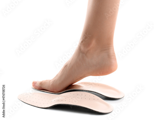 Female foot and orthopedic insoles on white background