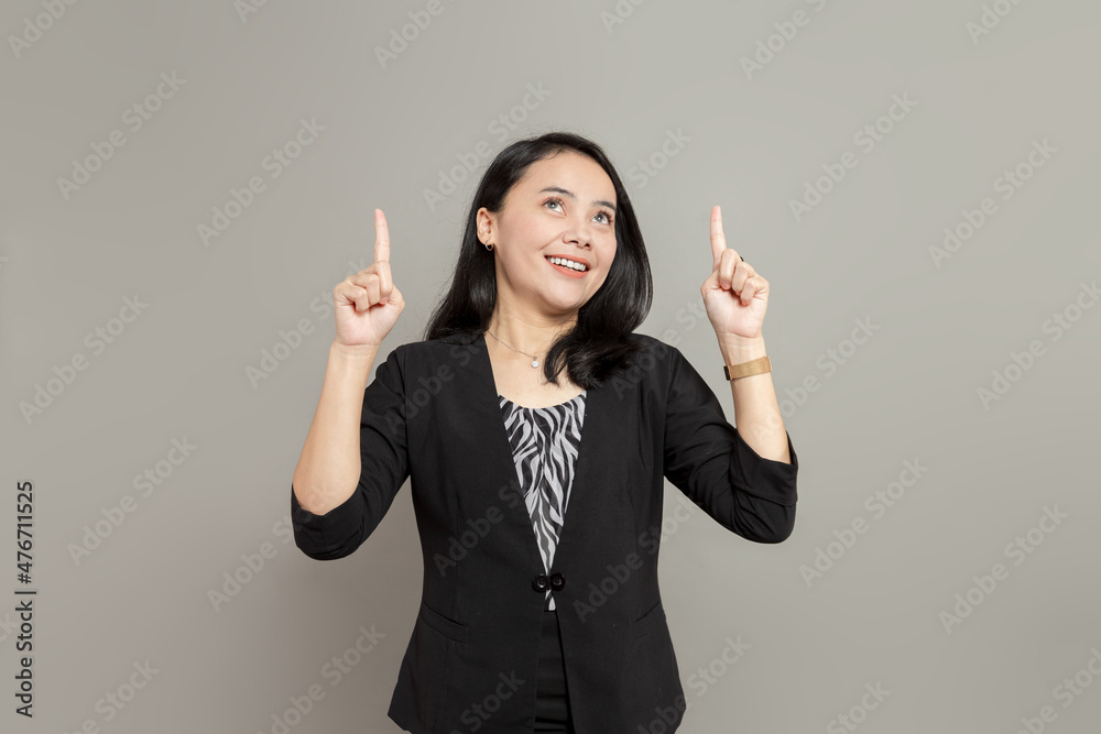 Young business woman wearing black suit looking up and pointing up with two hands Young business woman wearing black suit looking up and pointing up with two hands