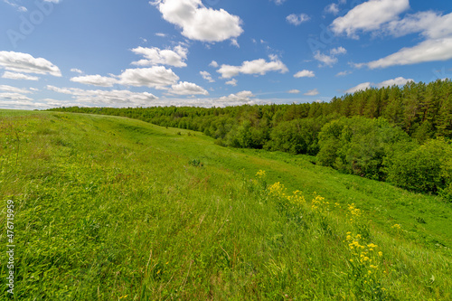 Spring photography, meadows, fields, ravines, hills, rural landscape. A deep, narrow gorge with steep slopes. A naturally raised area of ​​land, not as high or craggy as a mountain.