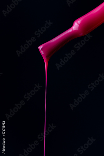 Close up of pink nail polish flow on black background with clipping path