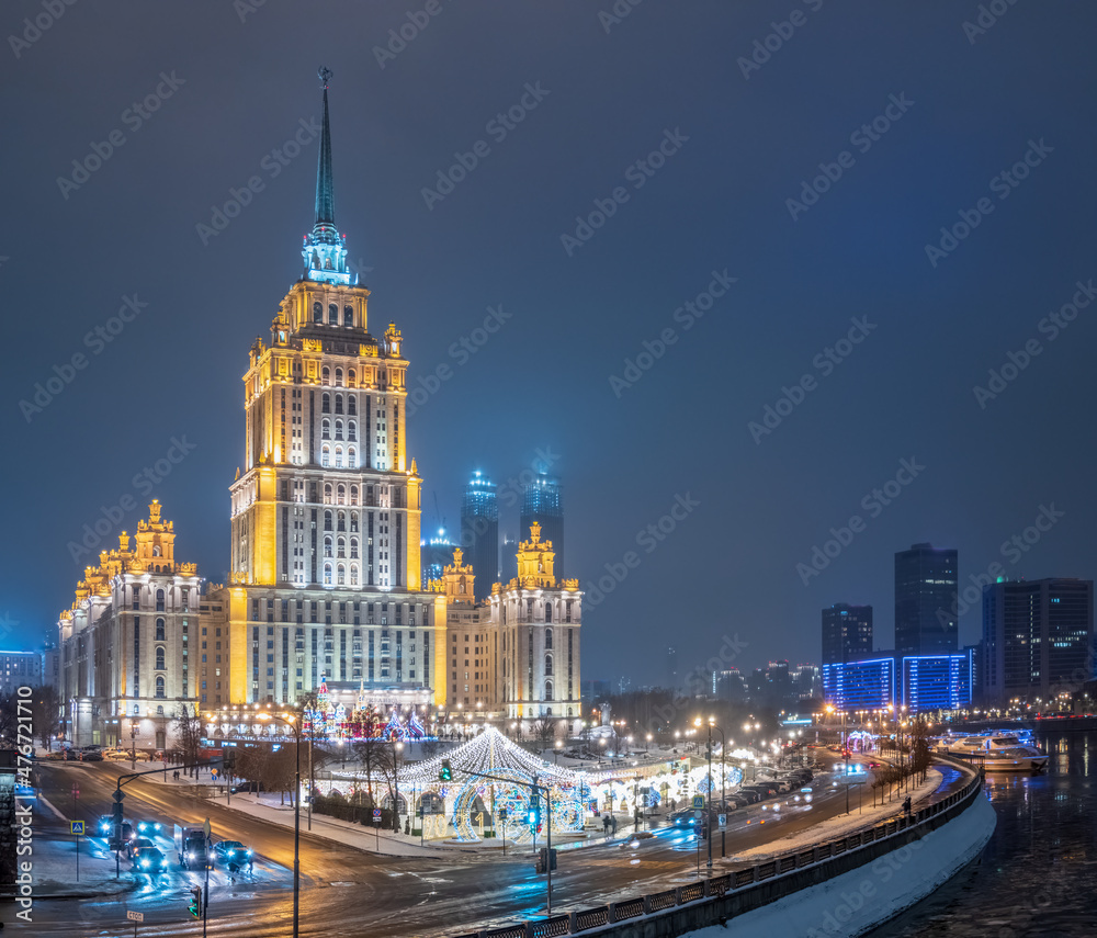 Illuminated high-rise stalinist building near river at winter night in Moscow, Russia. Historic name is Hotel Ukraine.