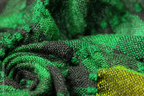 Fototapeta Naklejka Na Ścianę i Meble -  Texture, background, pattern. A woolen scarf to be worn around a person’s neck. Green black color on a scarf