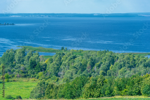 Summer landscape. River in the European part of the world. Sunny warm day. Green trees  grass. Blue sky with a small cloud cover.