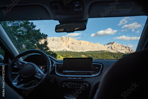 view from the car on the dolomites mountains illuminated by the sun