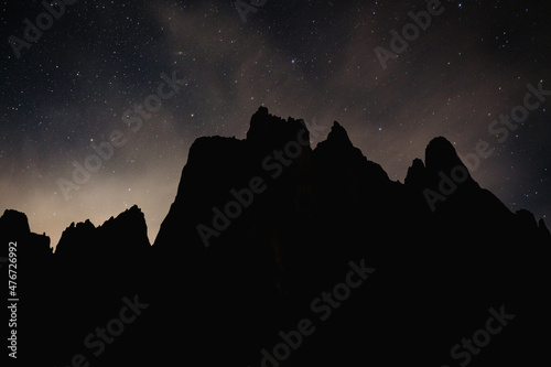 starry night over silhouette of mountains at night