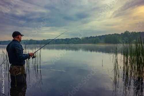 Fisherman catching fish on lake 