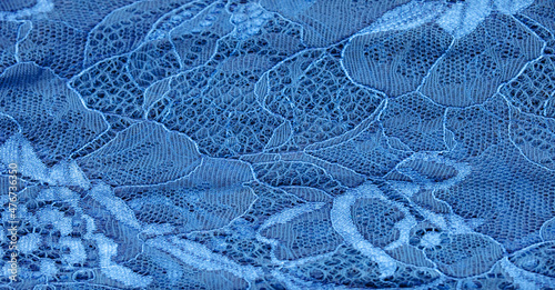 Blue lace fabric on a white background. Fancy African tulle lace fabric polyester with full length flowers for your design. The texture. Background. Pattern