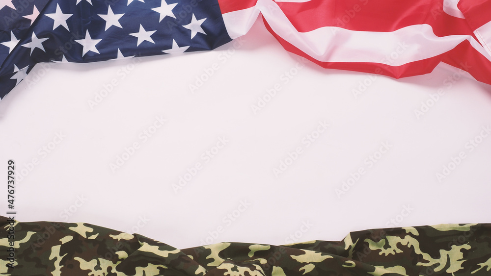 Fototapeta premium American flag and Military camouflage pattern. Top view angle. Soldier flag with national American flag on white background. Represent military concept by camouflage fabric and USA national flag.