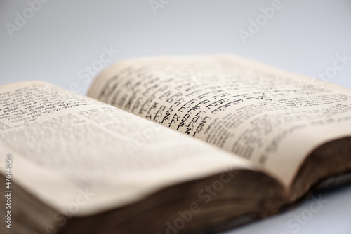 Closeup of worn shabby jewish holy book. Open page of Torah. Selective focus.