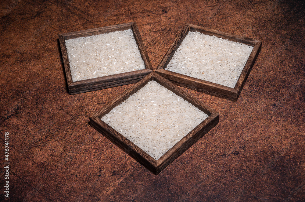 Fototapeta premium Some square containers of white rice in the dark background