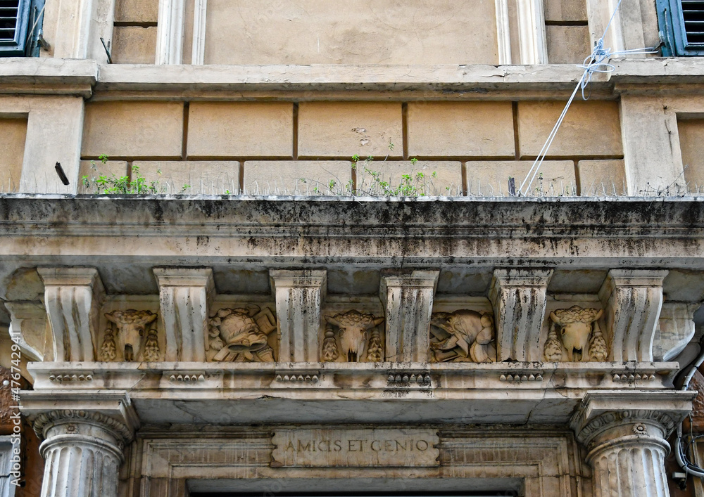 Detail of the façade of an old palace with a marble architrave decorated with bas-reliefs, Genoa, Liguria, Italy Detail of the façade of an old palace with a marble architrave decorated with bas-reliefs, Genoa, Liguria, Italy
