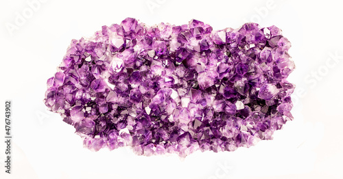 Purple crystalline mineral stone. Gems. Mineral crystals in the natural environment. The texture of precious and semiprecious stones. Isolated on white background colored shiny gemstone surface.