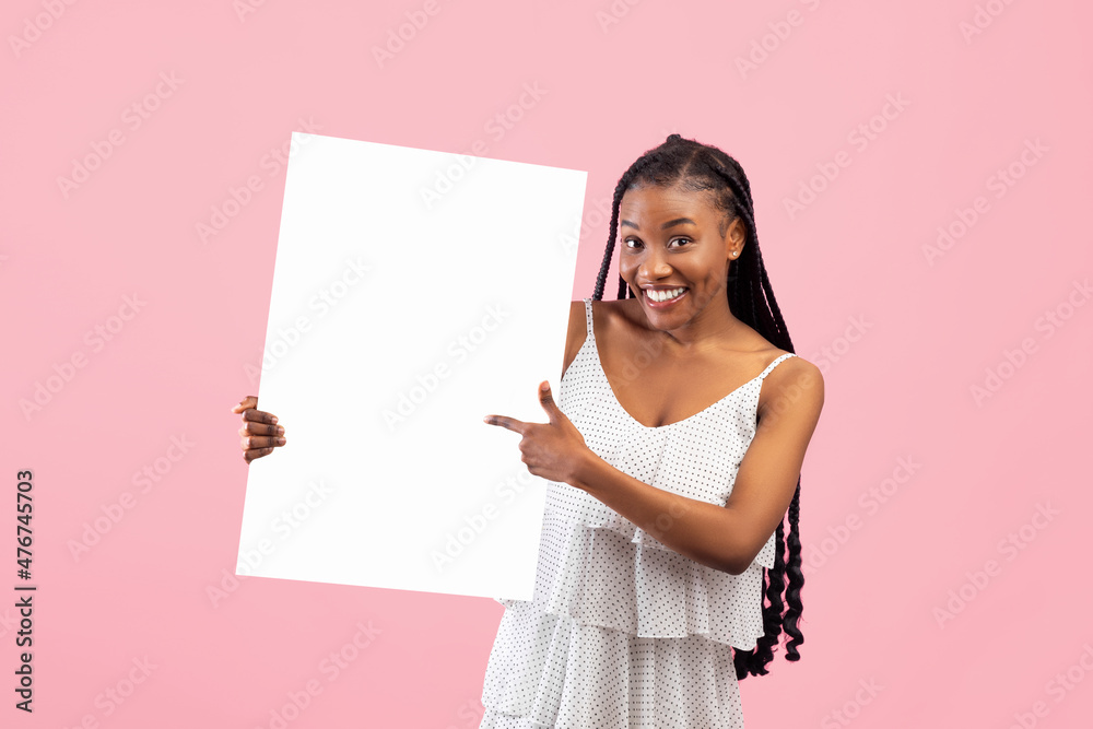 Smiling African American woman pointing at empty banner with space for your design on pink background Smiling African American woman pointing at empty banner with space for your design on pink background