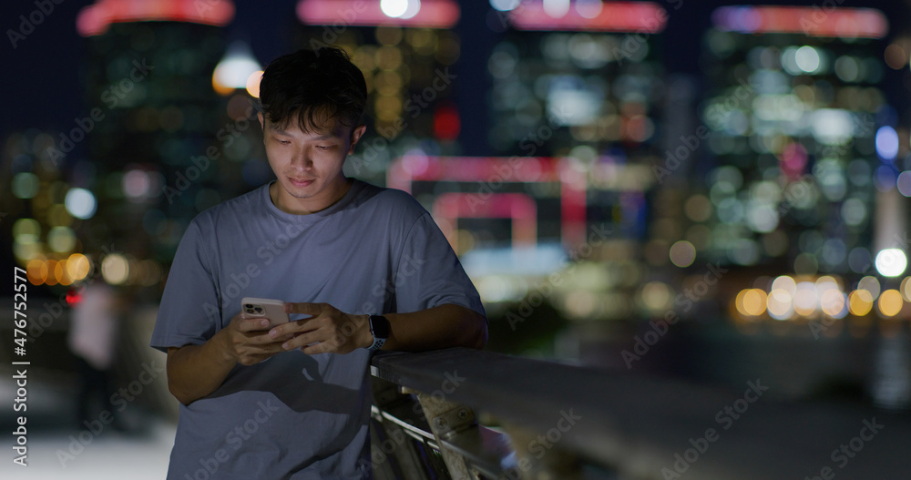 Man use of mobile phone in city at night Man use of mobile phone in city at night