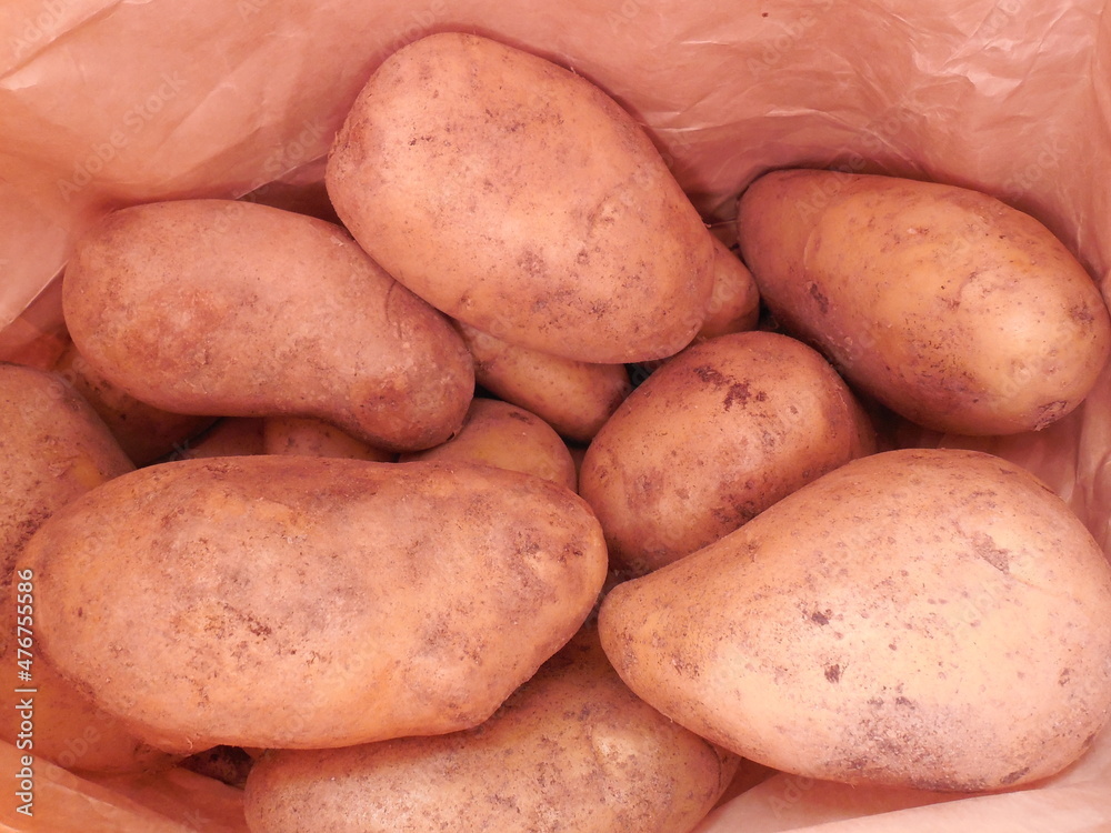 Potatoes, large unpeeled tubers in a paper bag. Potatoes, large unpeeled tubers in a paper bag.