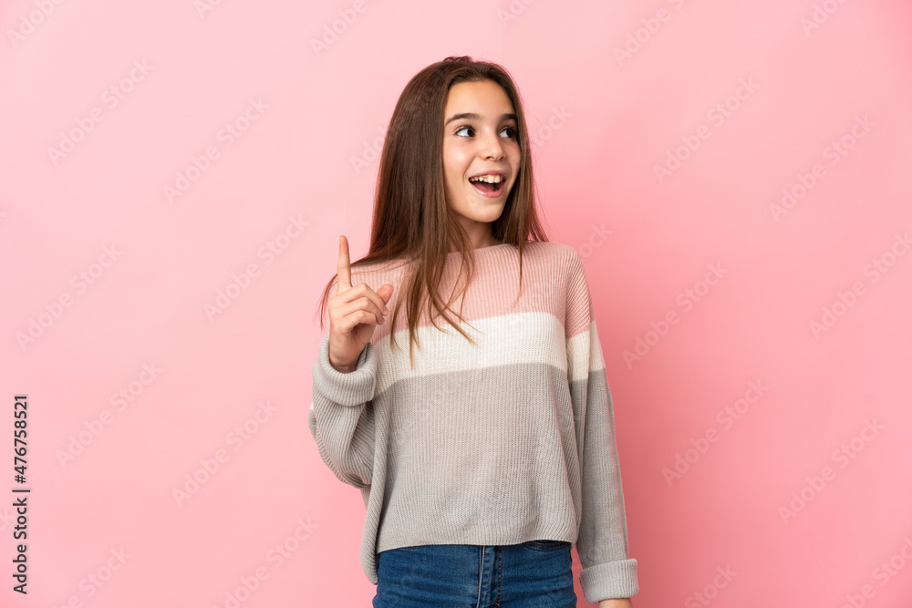 Little girl isolated on pink background pointing up and surprised Little girl isolated on pink background pointing up and surprised