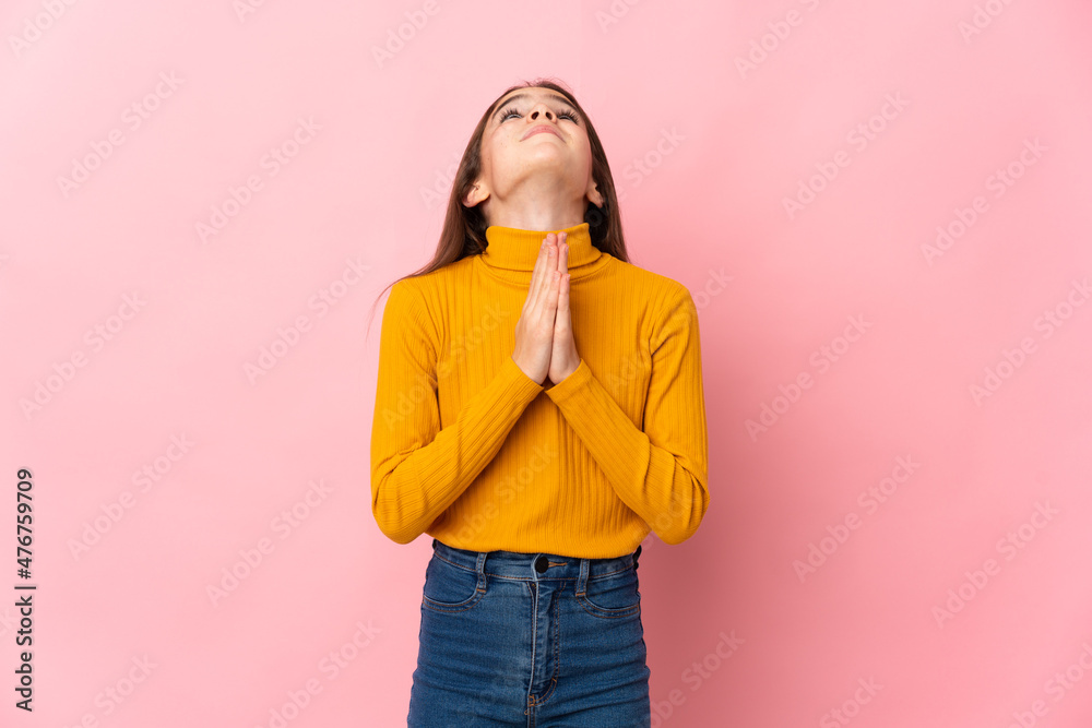 Little girl isolated on pink background keeps palm together. Person asks for something