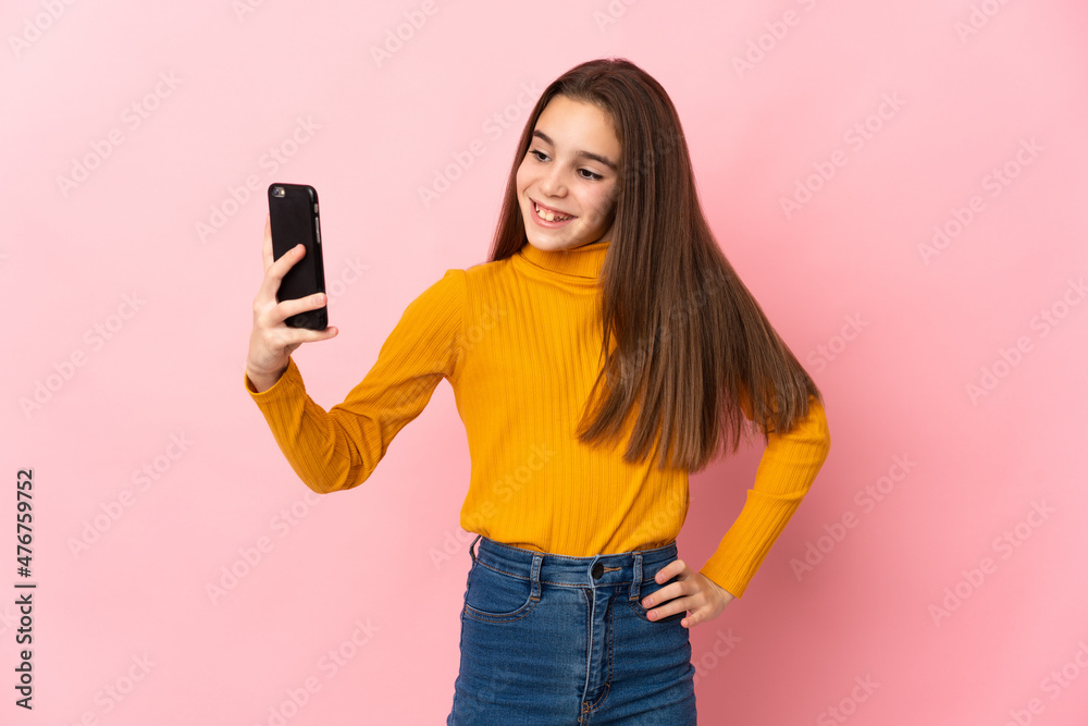 Little girl isolated on pink background making a selfie Little girl isolated on pink background making a selfie