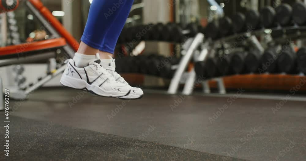 Legs of a woman in sneakers jumping rope in the gym, close-up Legs of a woman in sneakers jumping rope in the gym, close-up