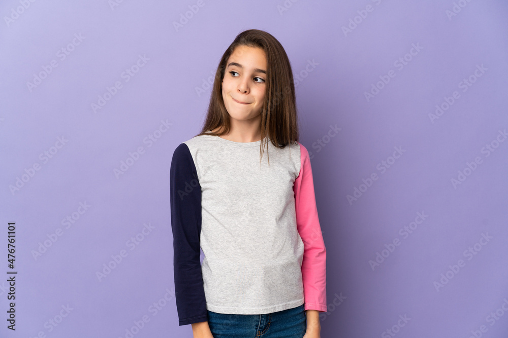 Little girl isolated on purple background having doubts while looking up Little girl isolated on purple background having doubts while looking up