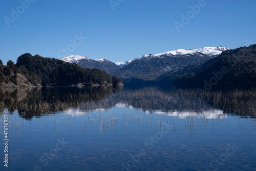 Beauty in nature. View of volcano Batea Mahuida, Andes mountains, forest and Alumine lake in Villa Pehuenia, Patagonia Argentina. Beautiful landscape and blue sky reflection in the glacier water.