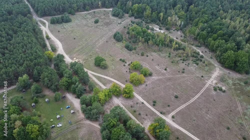 Northern forest and meadow . Harmony and meditation of nature. Panorama video of the cloudy horizon from the drone. Сoniferous and deciduous forest. Dirt road in the field and tourist camp. Northern forest and meadow . Harmony and meditation of nature. Panorama video of the cloudy horizon from the drone. Сoniferous and deciduous forest. Dirt road in the field and tourist camp.