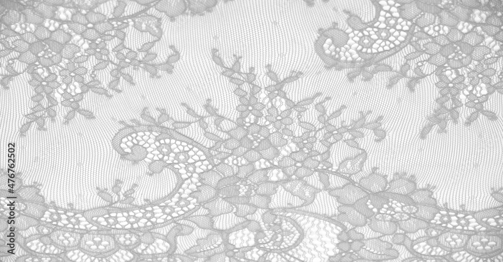 lace fabric. bird feather. white on a white background. Delicately crafted from yarn or thread, lace fabrics have historically embodied class and beauty since their inception in the 16th century.