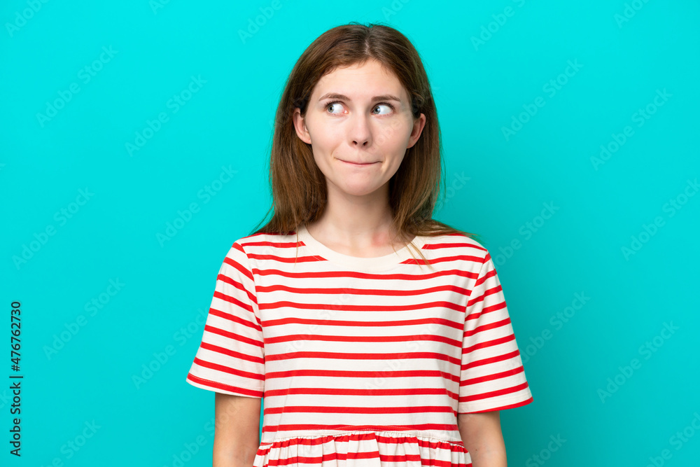 Young English woman isolated on blue background having doubts while looking up Young English woman isolated on blue background having doubts while looking up