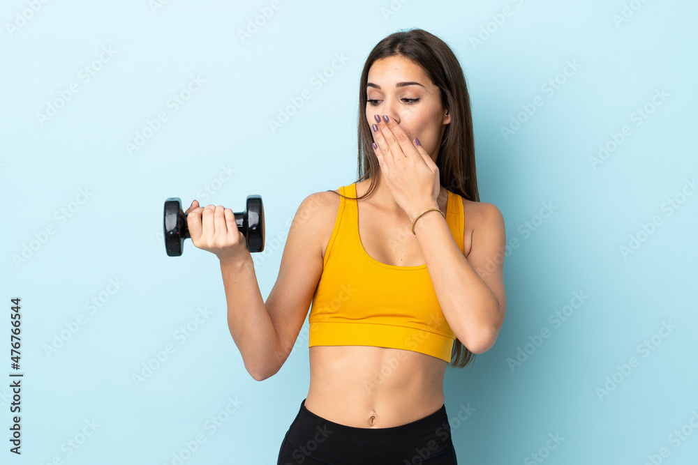 Young caucasian woman making weightlifting isolated on blue background with surprise and shocked facial expression Young caucasian woman making weightlifting isolated on blue background with surprise and shocked facial expression