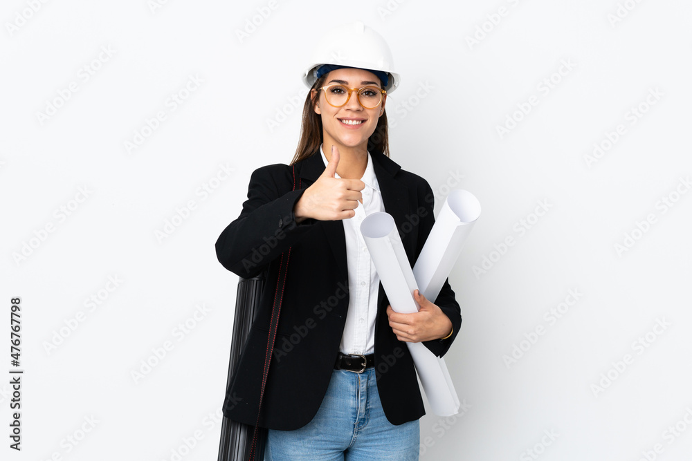 Young architect caucasian woman with helmet and holding blueprints over isolated background giving a thumbs up gesture Young architect caucasian woman with helmet and holding blueprints over isolated background giving a thumbs up gesture