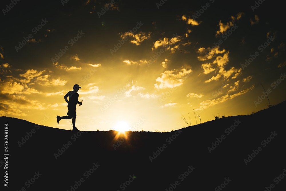 Silhouette of a man running freely in the mountains.